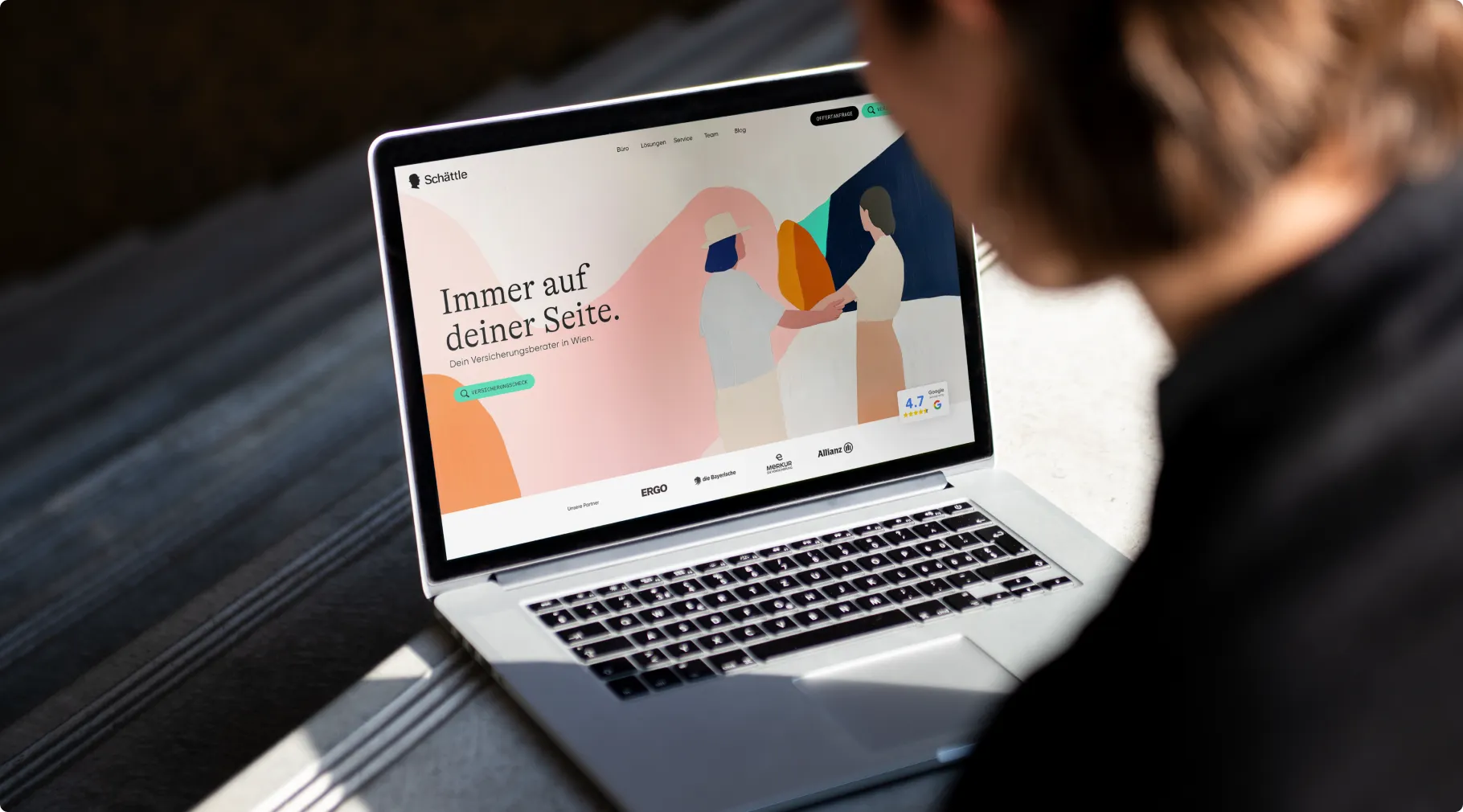 Hand hält ein Smartphone mit der neuen Schättle-Website